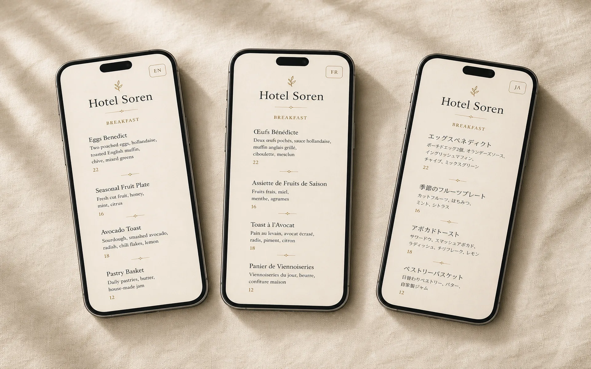 Three phones laid side by side on cream linen, each showing the same Hotel Soren breakfast menu in a different language — English, French, and Japanese — with identical layout and masthead